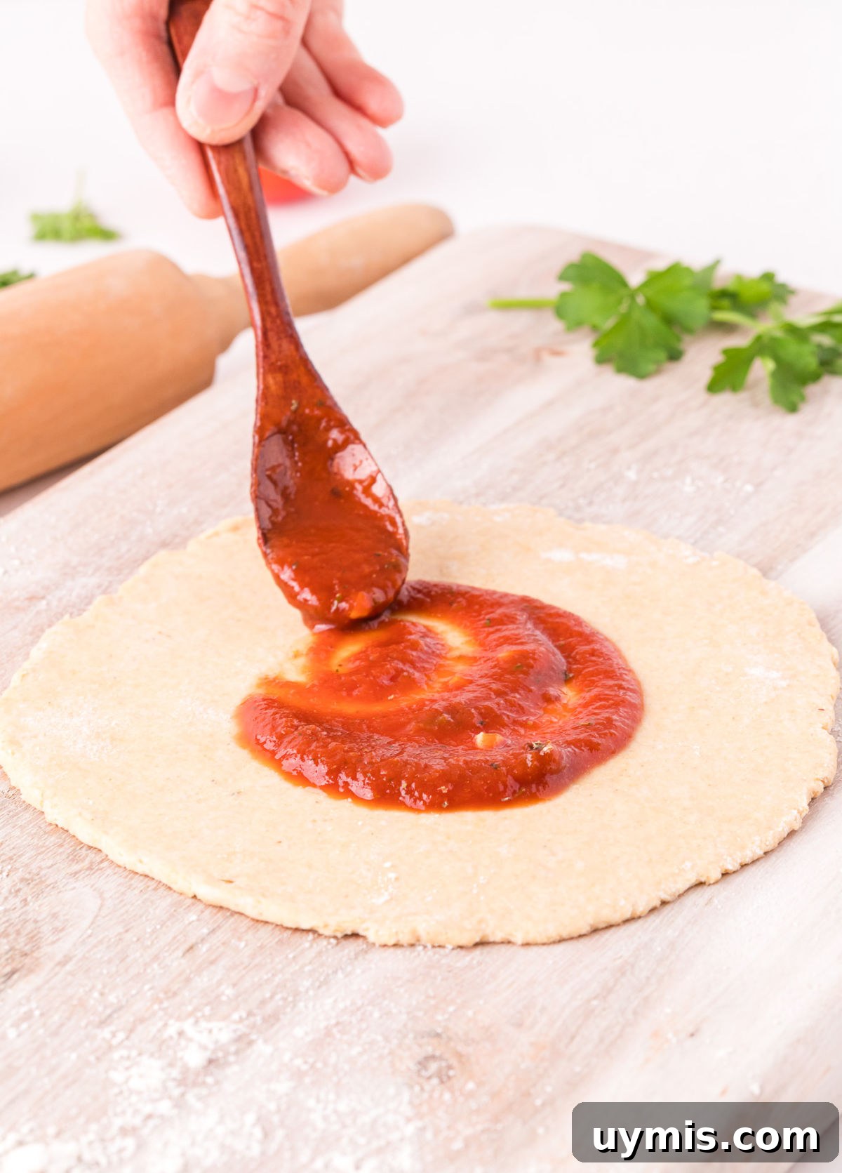 Homemade Pizza Sauce Recipe Without Tomato Paste 2 Pizza sauce being spread on pizza dough.