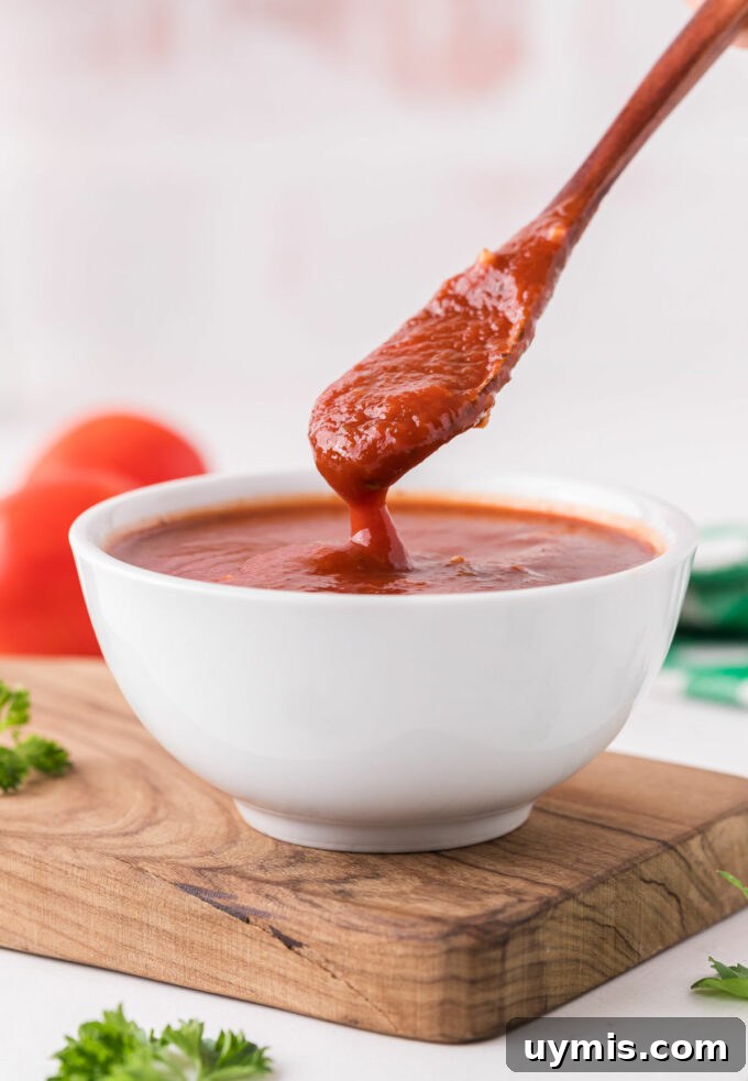 Homemade Pizza Sauce Recipe Without Tomato Paste 6 Spooning pizza sauce out of a bowl.