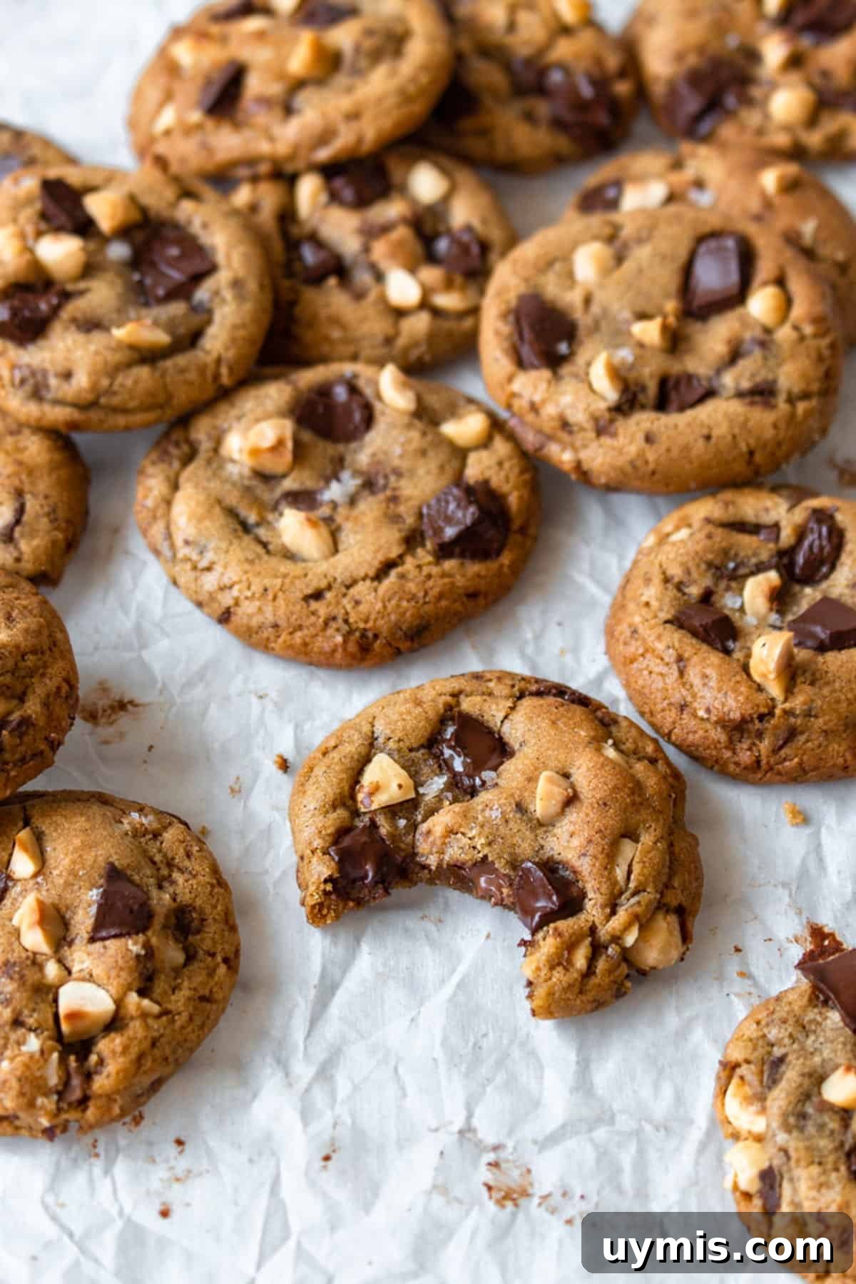 Chewy Brown Butter Chocolate Chip Cookies 2 Brown butter chocolate chip cookies scattered on a white surface.