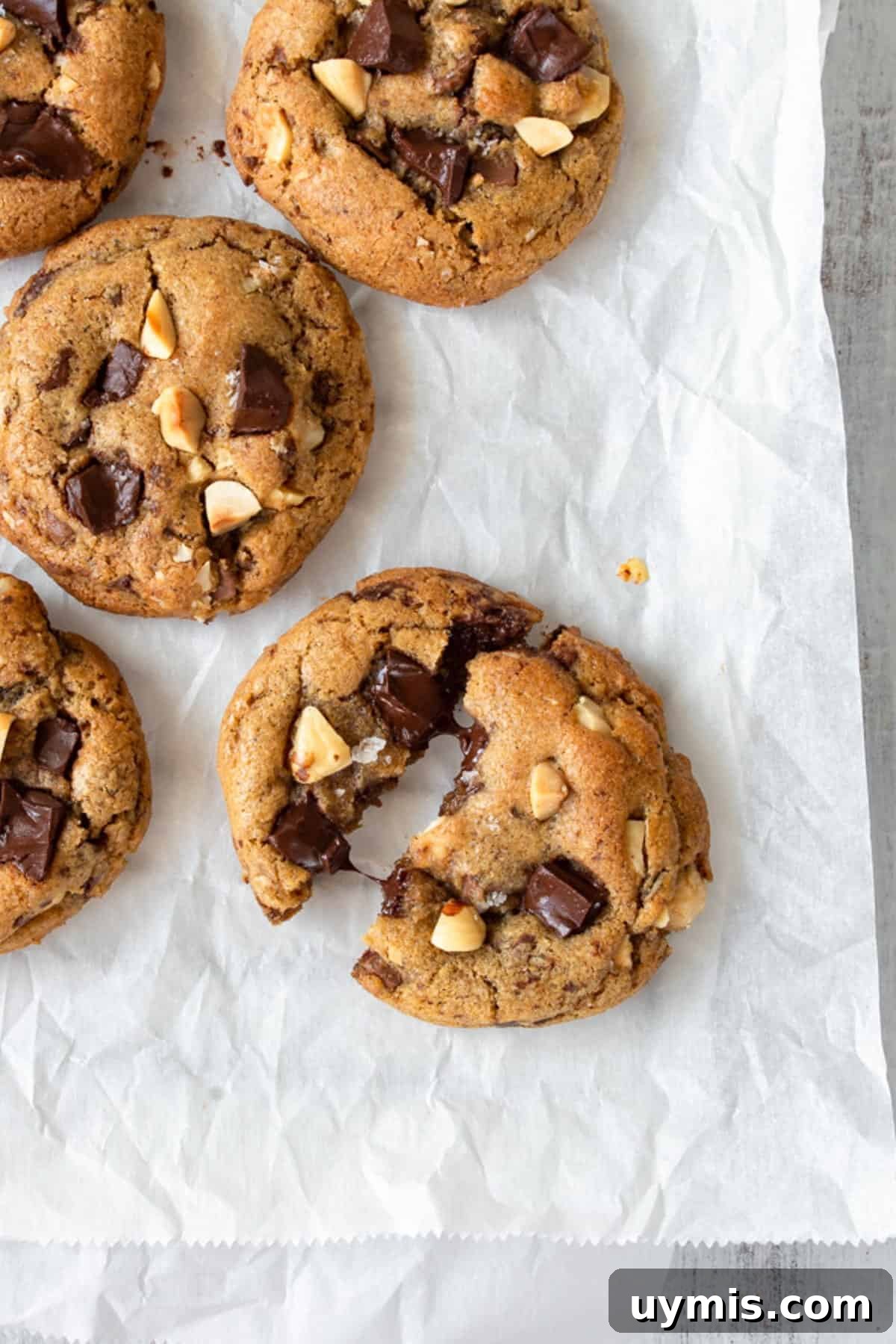 Chewy Brown Butter Chocolate Chip Cookies 5 A brown butter cookie broken in half, with more cookies on the side.