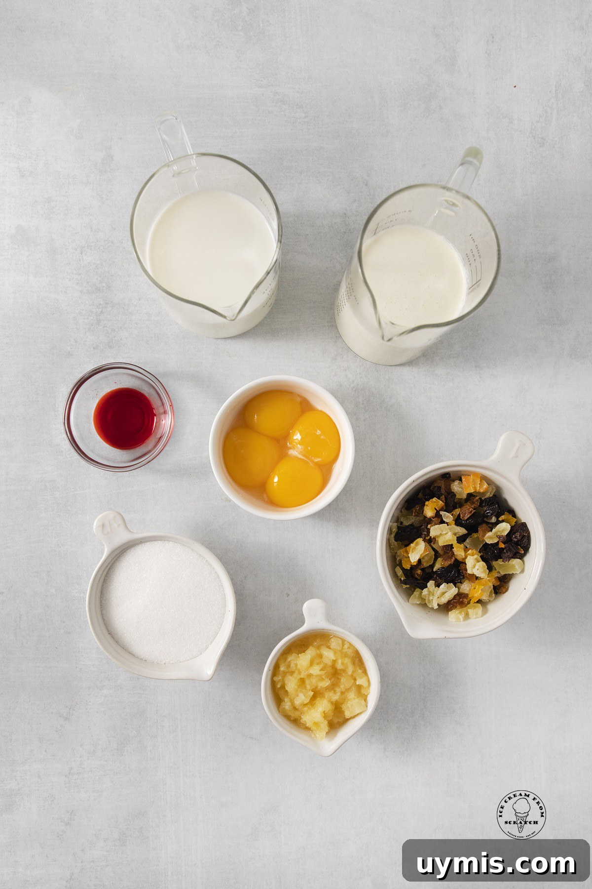Homemade Tutti Frutti Ice Cream Recipe 3 The ingredients needed to make a french style tutti frutti ice cream recipe, with dried fruit, egg yolks, sugar, and milk, all measured out into individual containers.