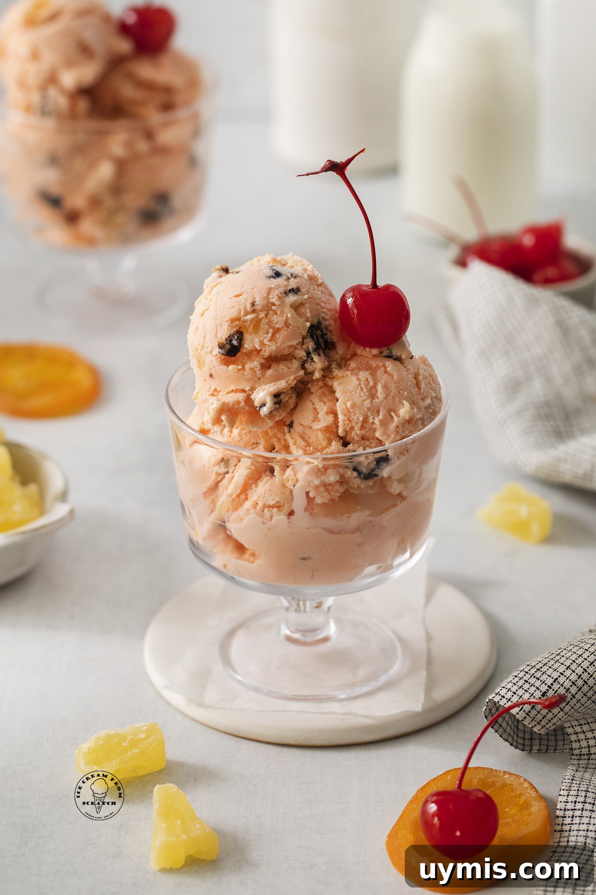 Homemade Tutti Frutti Ice Cream Recipe 4 A footed glass dish of tutti frutti ice cream with a cherry on top.
