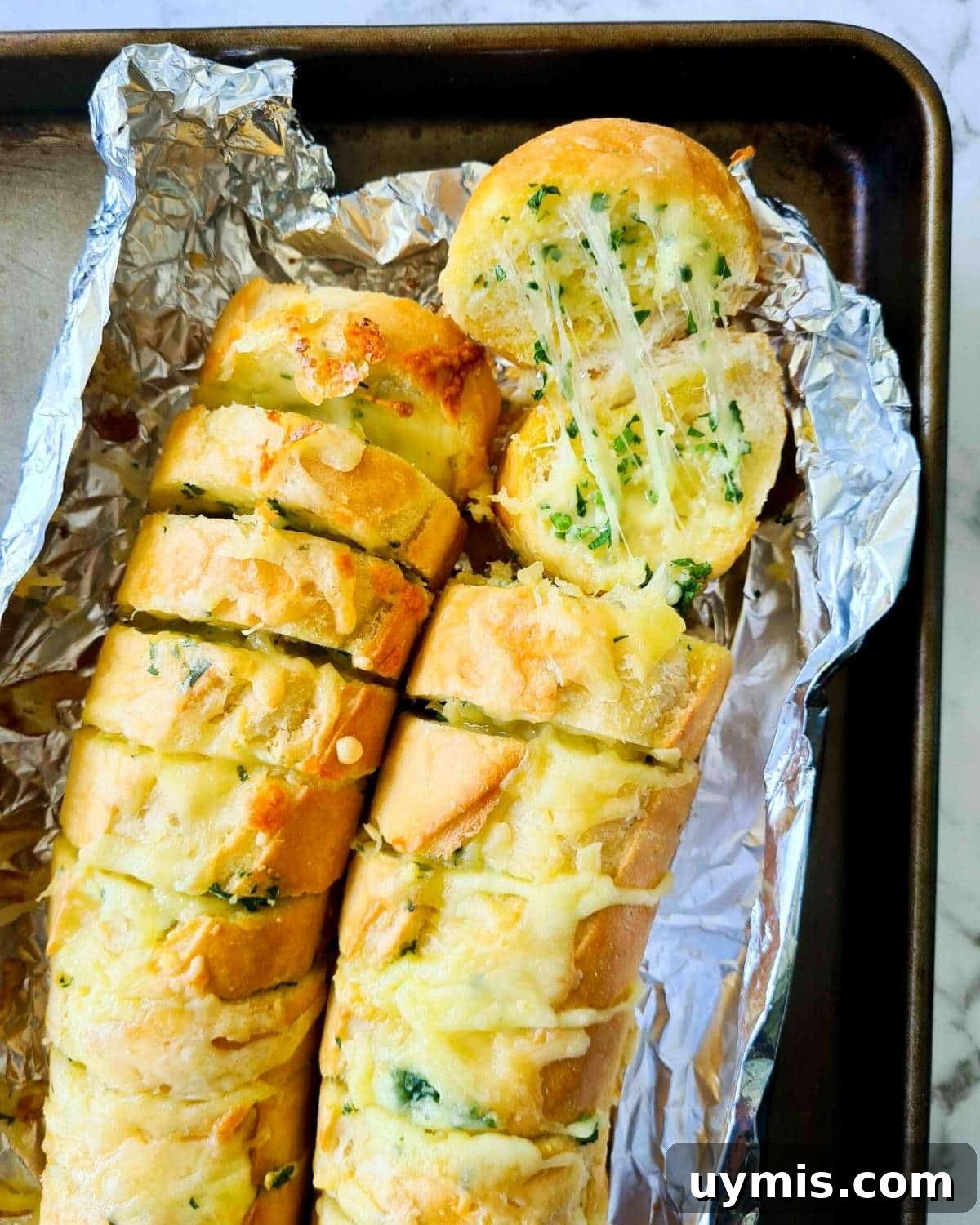 Cheesy garlic bread straight out of the oven with visible strechy, melted cheese