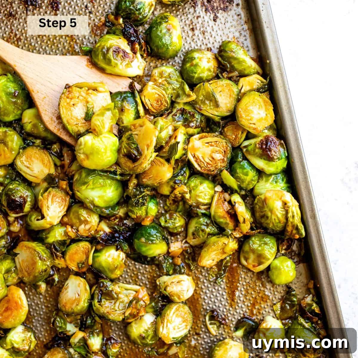 Crispy Honey Sriracha Brussels Sprouts 6 Roasted Brussels sprouts on a baking sheet coated with honey Sriracha sauce.