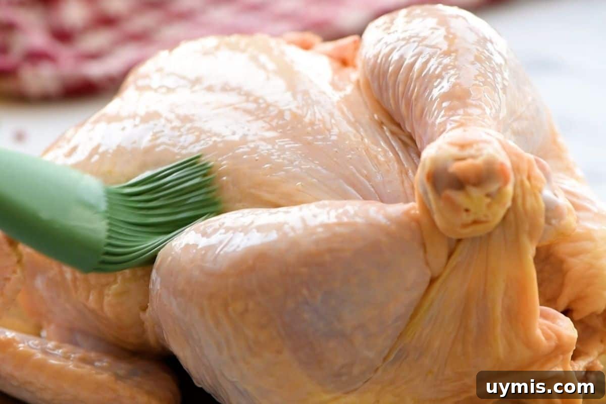 Chicken being brushed with oil.