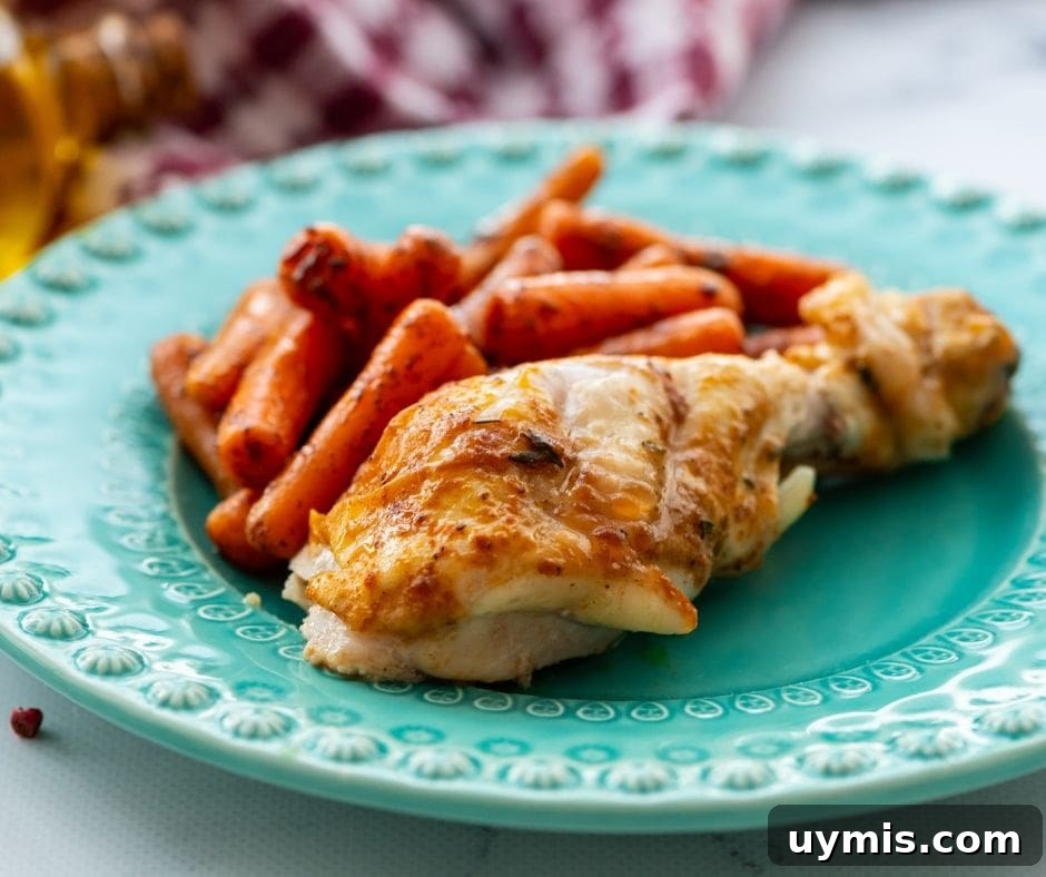Rotisserie chicken on a blue plate with roasted carrots.