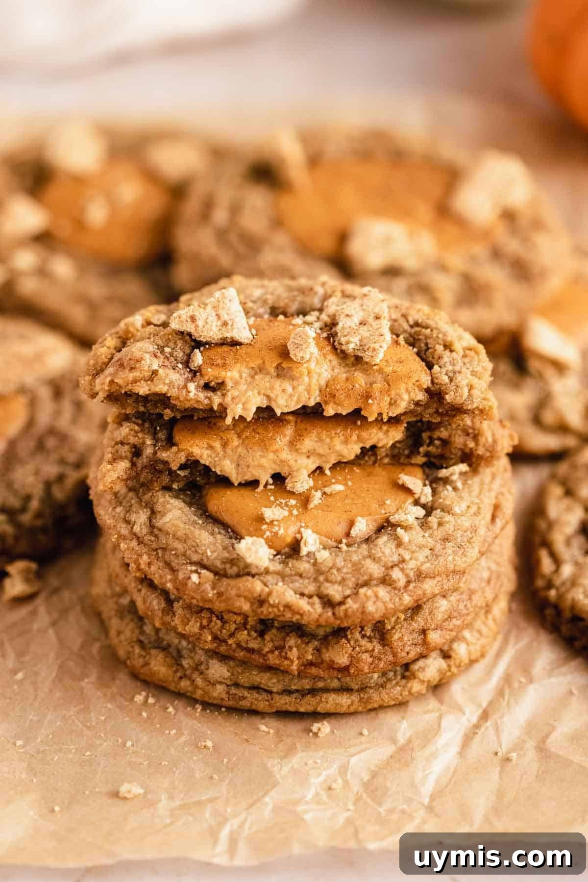 Soft Pumpkin Cheesecake Cookies with Cream Cheese Swirl 2 stack of pumpkin cheesecake cookies on parchment paper