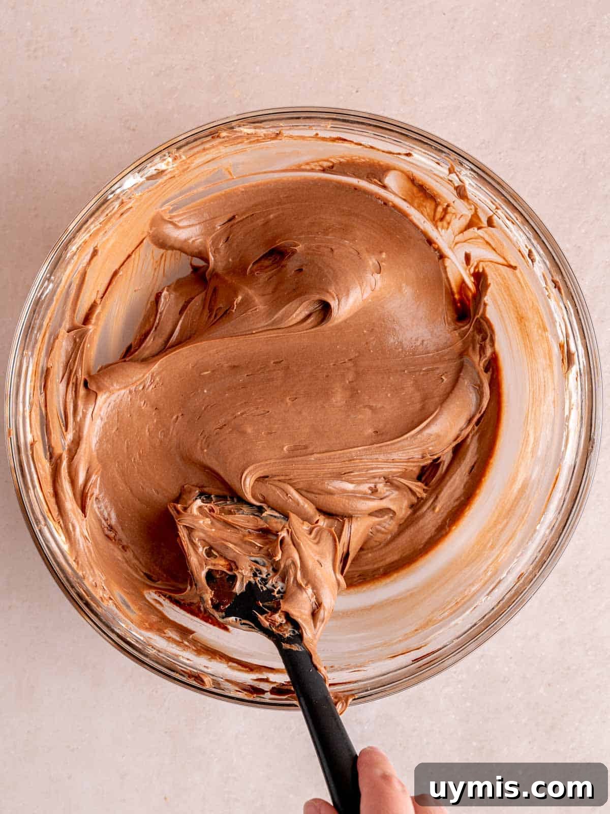 Creamy No-Bake Chocolate Cherry Cheesecake Recipe 11 Folding chocolate ganache into no bake cheesecake filling with a spatula.