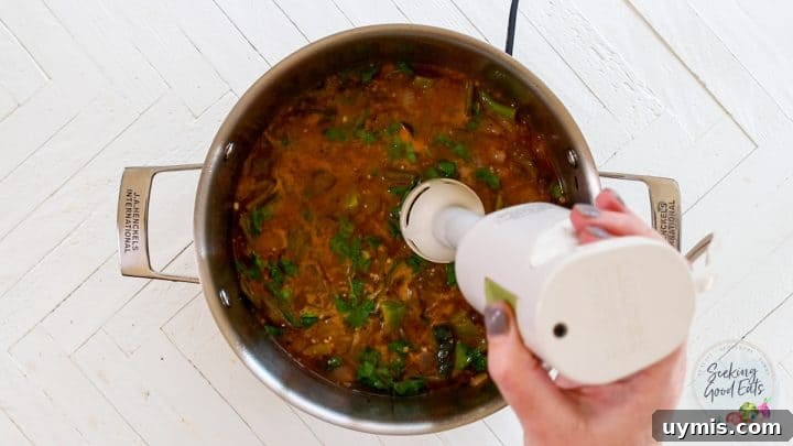 Blending the sauce with a hand held blender.