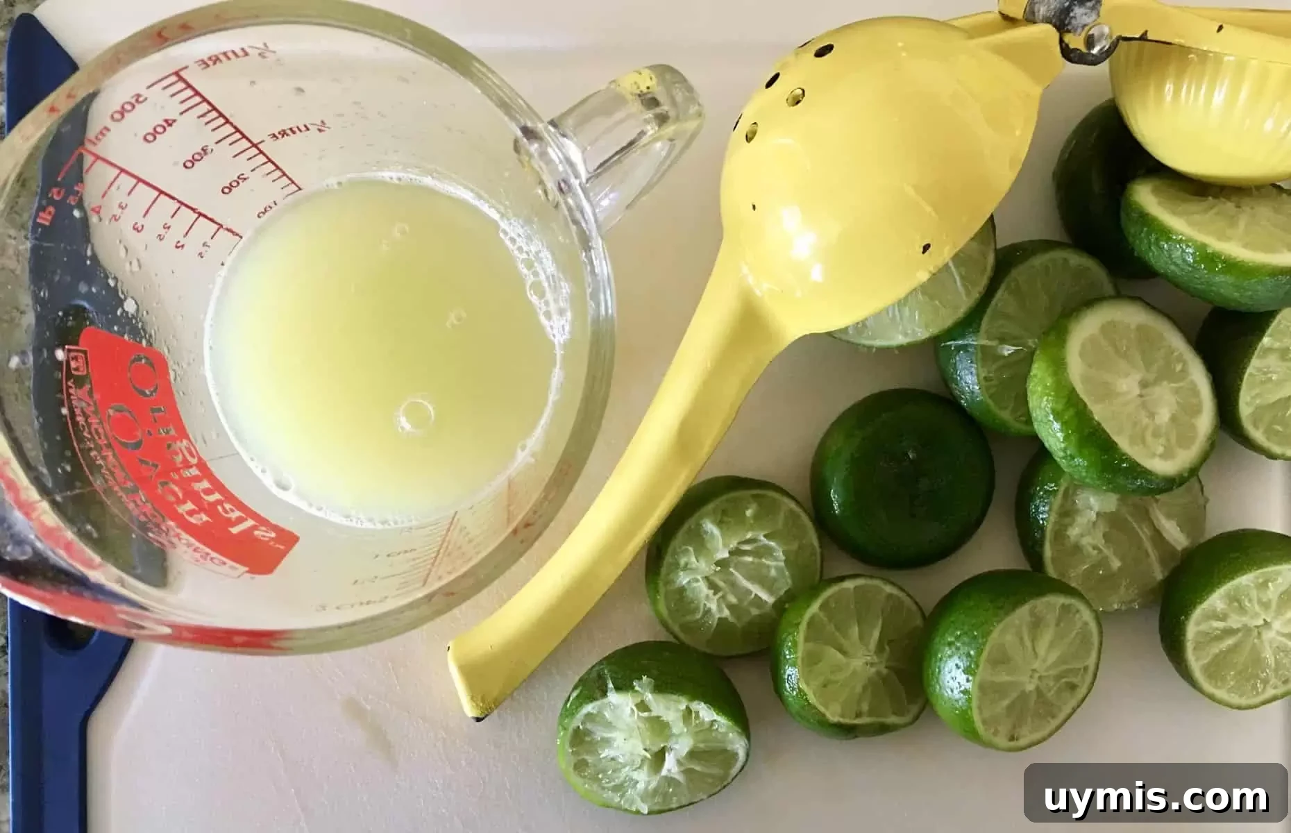 How to Make a Pineapple Margarita Cocktail 4 cutting board with limes and lime juice on it.