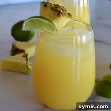 How to Make a Pineapple Margarita Cocktail 5 Glass of pineapple margarita with a lime and pineapple garnish.