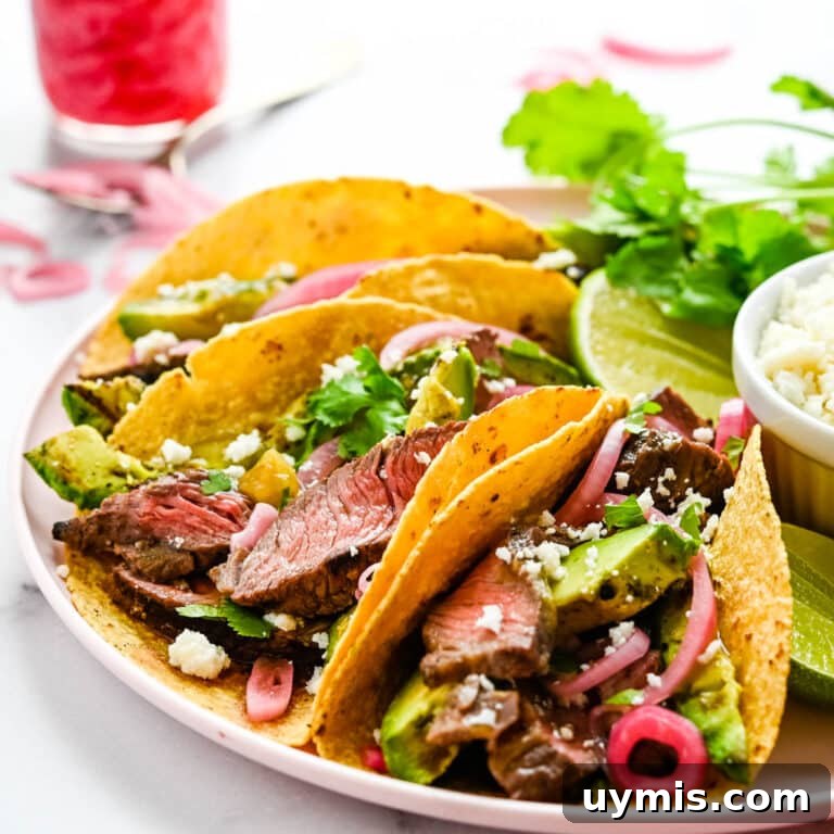 Carne Asada Tacos with Juicy Grilled Steak 13 A platter of carne asada tacos with pickled onions.