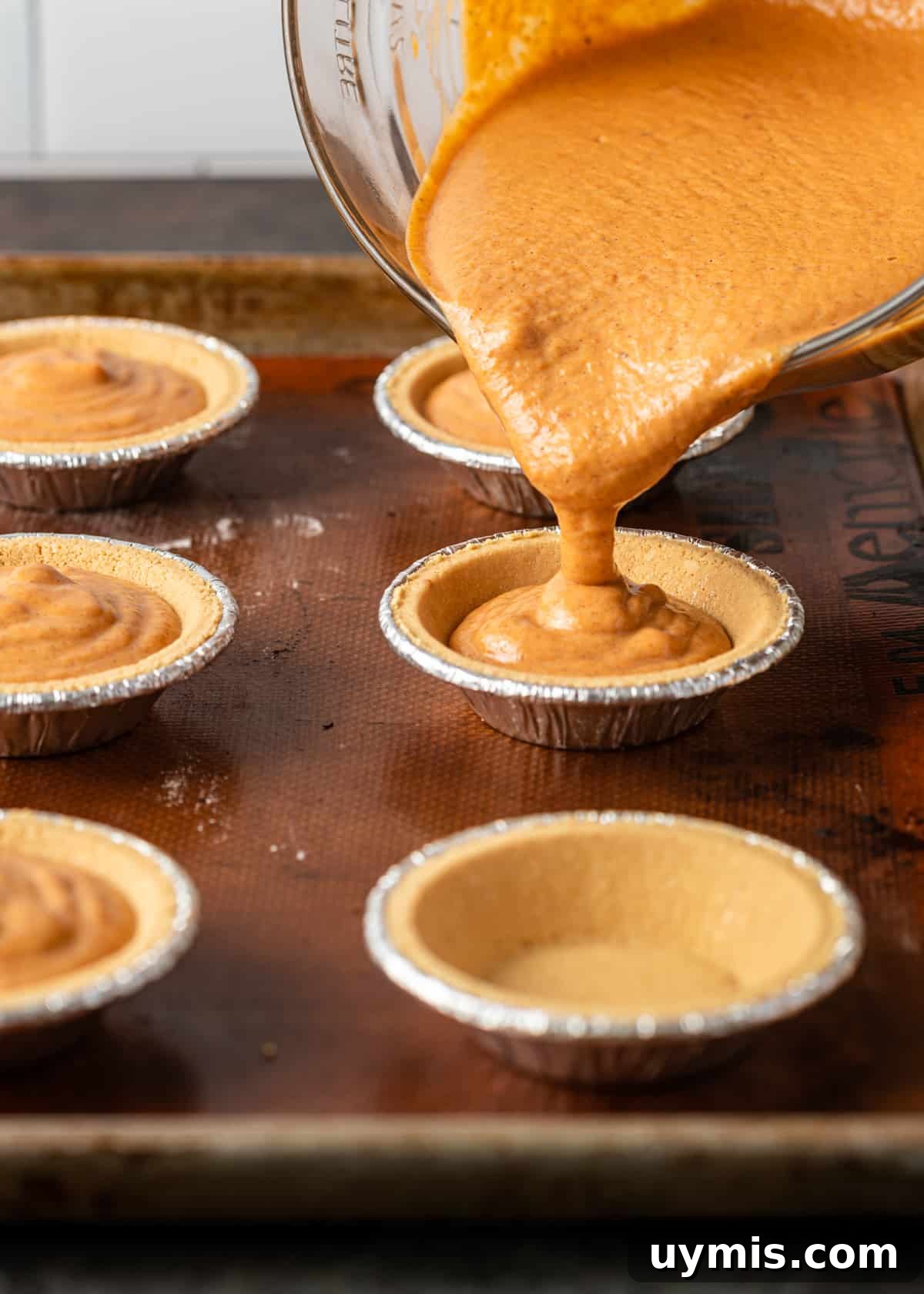 Mini Pumpkin Pies Recipe for Thanksgiving 5 pouring pumpkin pie filling into pie crust