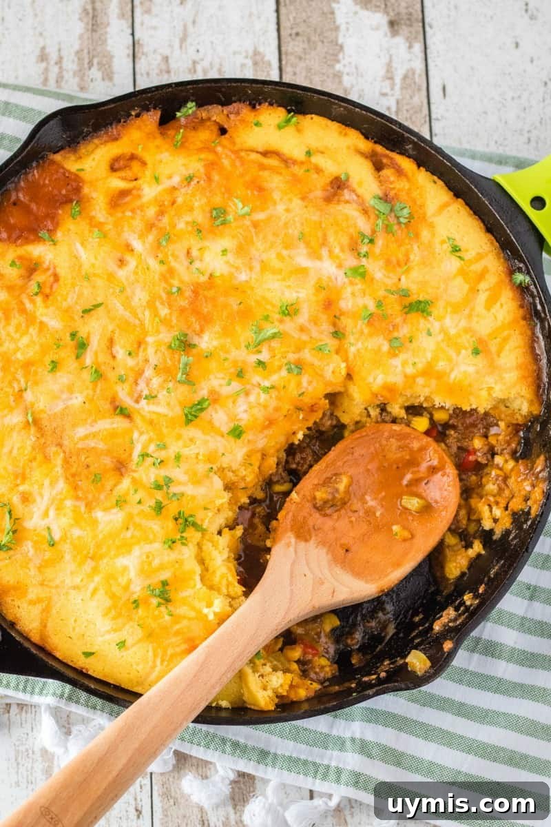 Skillet Sloppy Joe Cornbread with a serving spoon