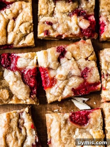 Raspberry white chocolate blondies on a wooden cutting board.