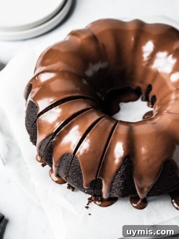 Close up of sliced bundt cake on a white marble background