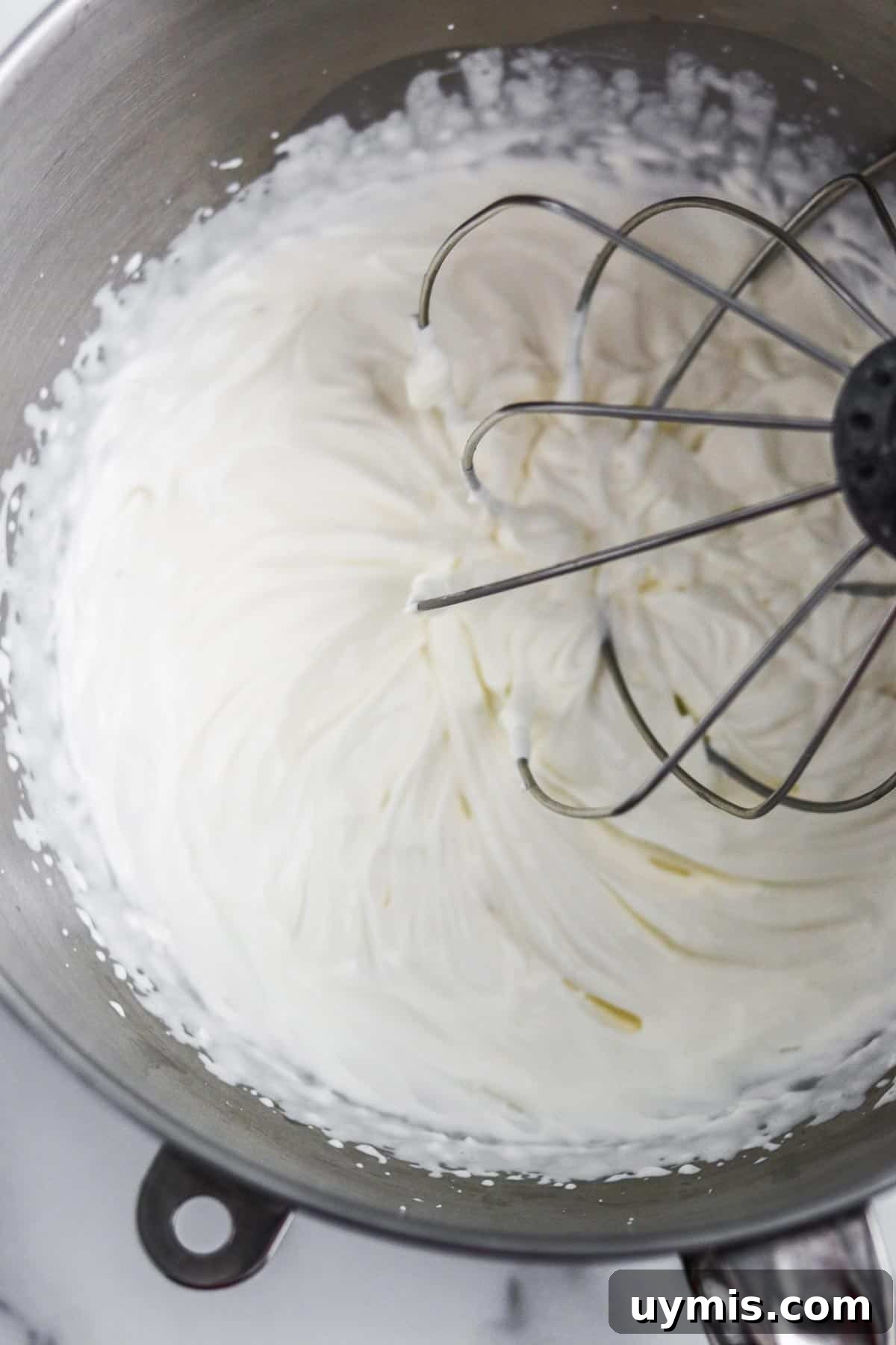 Multekrem: Norwegian Cloudberry Cream Recipe 6 Whipped cream in a metal bowl with a whisk.