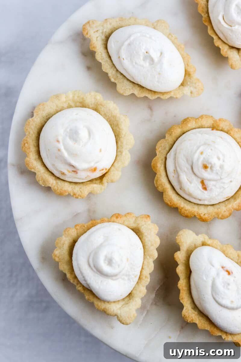 Multekrem: Norwegian Cloudberry Cream Recipe 7 Scandinavian Almond Tarts filled with Cloudberry Cream on a marble surface.