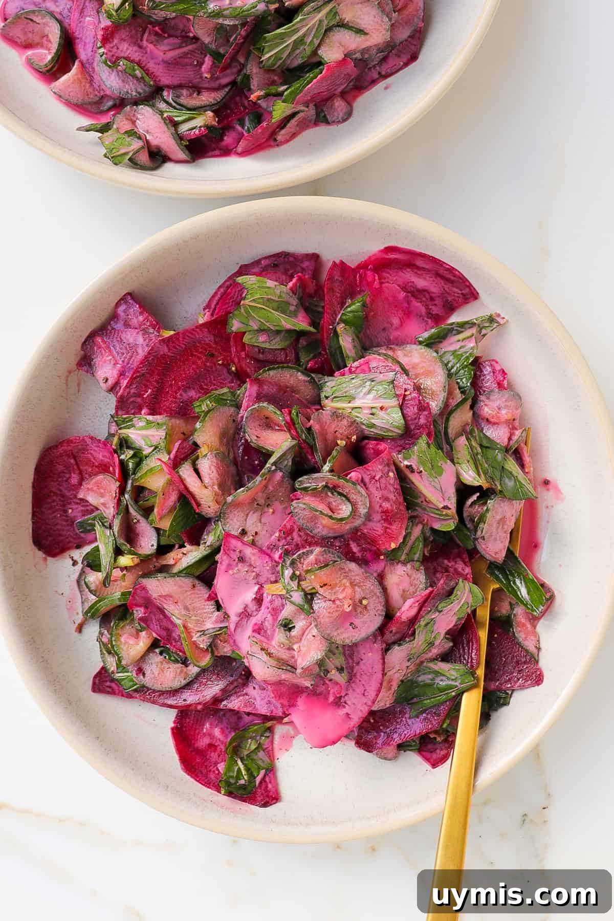 Cucumber and Beetroot Salad Recipe 9 Cucumber beetroot salad in bowl with gold fork.