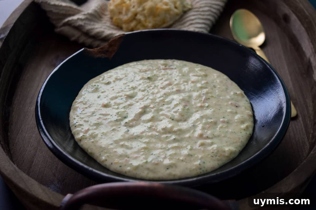Creamy Homemade Broccoli Cheddar Soup Recipe 7 Soup in rustic bowl on wooden platter close up view