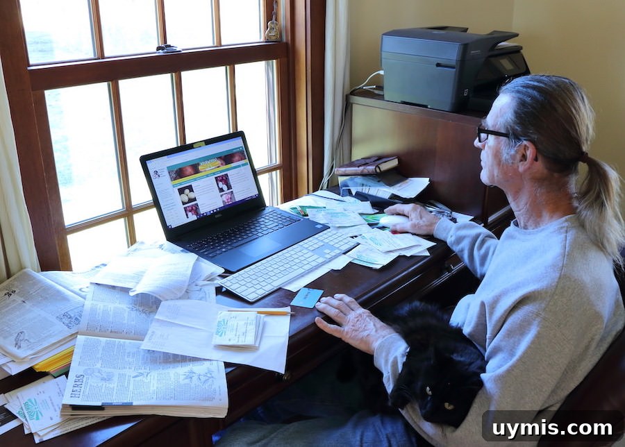 Plan Your Garden: When to Buy Seeds and Start Planting 5 Jamie sitting at his desk with out cat on his lap, using his computer to order seeds