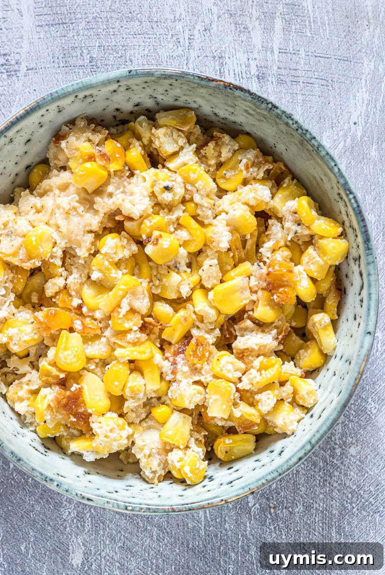 Creamy Scalloped Corn Casserole Recipe 7 a blue bowl filled with scalloped corn casserole