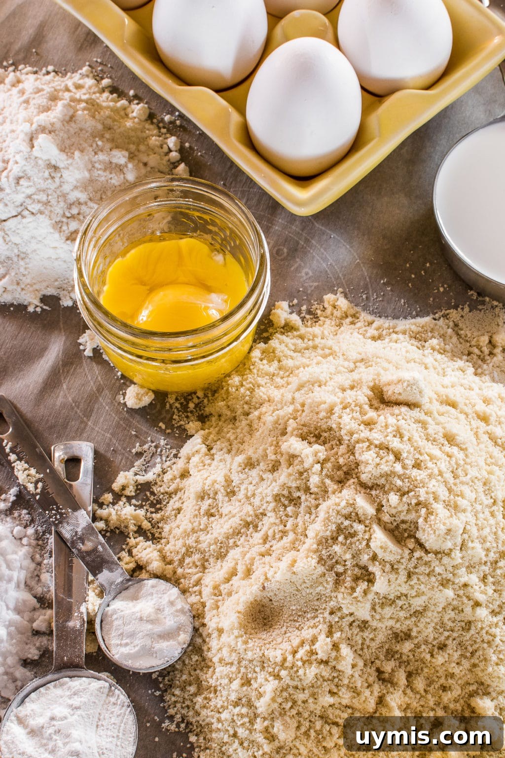 Keto Sugar Free Birthday Cake Everyone Will Love 3 A table of baking ingredients with flours, eggs, and measuring spoons.