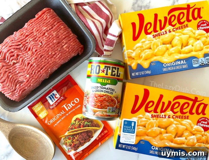 Taco Macaroni and Cheese Skillet Dinner 3 Four simple ingredients for taco macaroni and cheese: ground beef, boxed macaroni, taco seasoning, and diced tomatoes with green chilies.