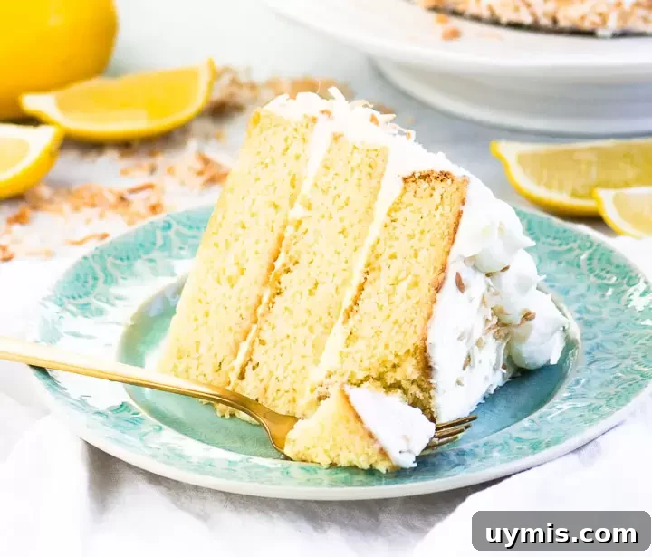 Lemon Coconut Cake with Creamy Coconut Frosting 7 slice of lemon coconut cake on a plate with a fork taking a bite out of it