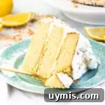 Lemon Coconut Cake with Creamy Coconut Frosting 8 slice of lemon coconut cake on a plate with a fork taking a bite out of it