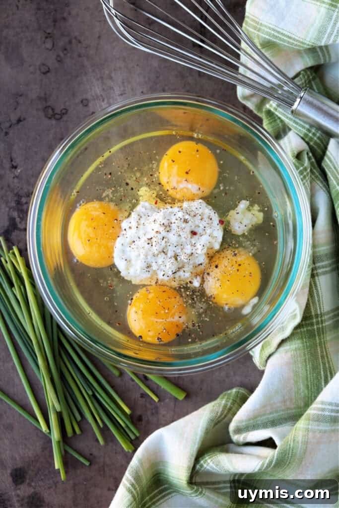 eggs in a clear bowl with cottage cheese and seasonings
