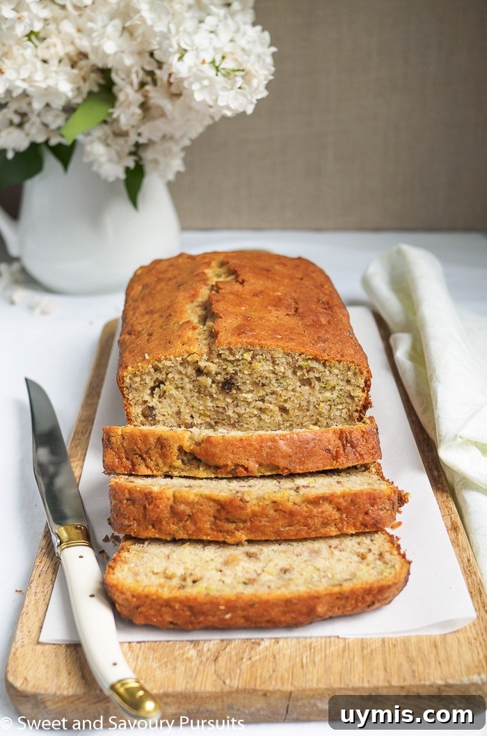 Zesty Lemon Zucchini Loaf Recipe 3 Lemon Zucchini Walnut Loaf on cutting board with cut slices.
