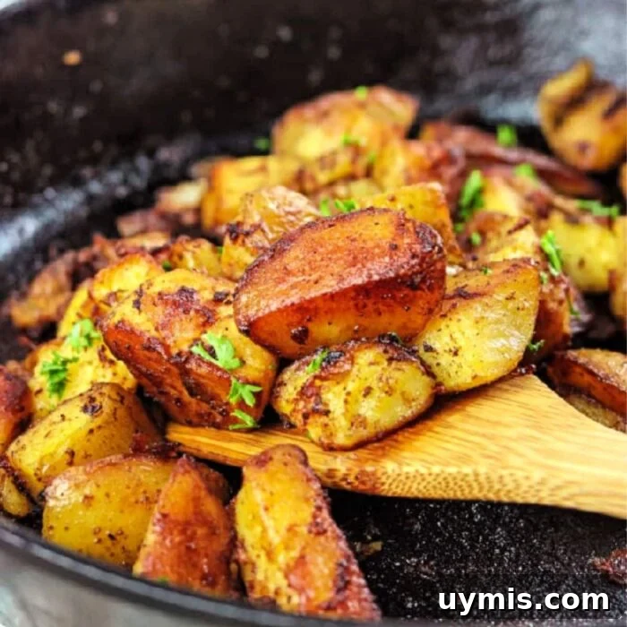 Old Fashioned Sloppy Joes Recipe 12 Wooden spatula removing fried potatoes out of iron skillet.