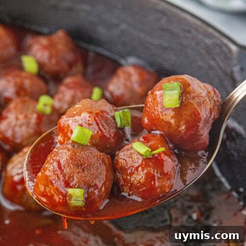 Cranberry sauce meatballs in an iron skillet.