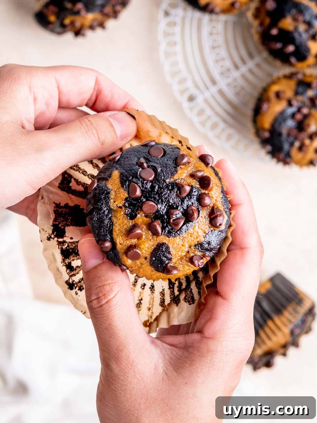 Unwrapping a marbled pumpkin chocolate muffin.