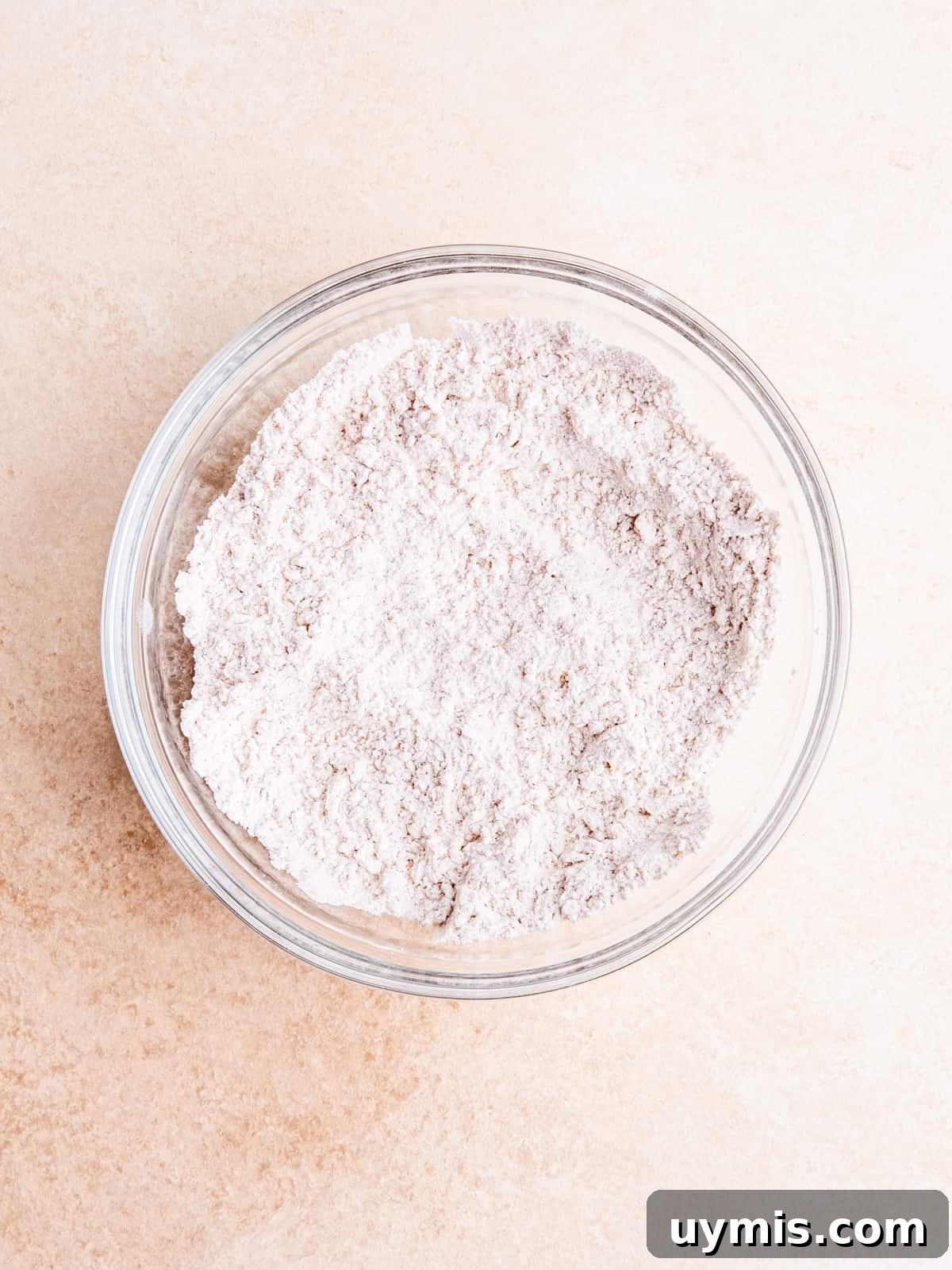 Whisking flour, baking soda, salt and pumpkin pie spice in a bowl.