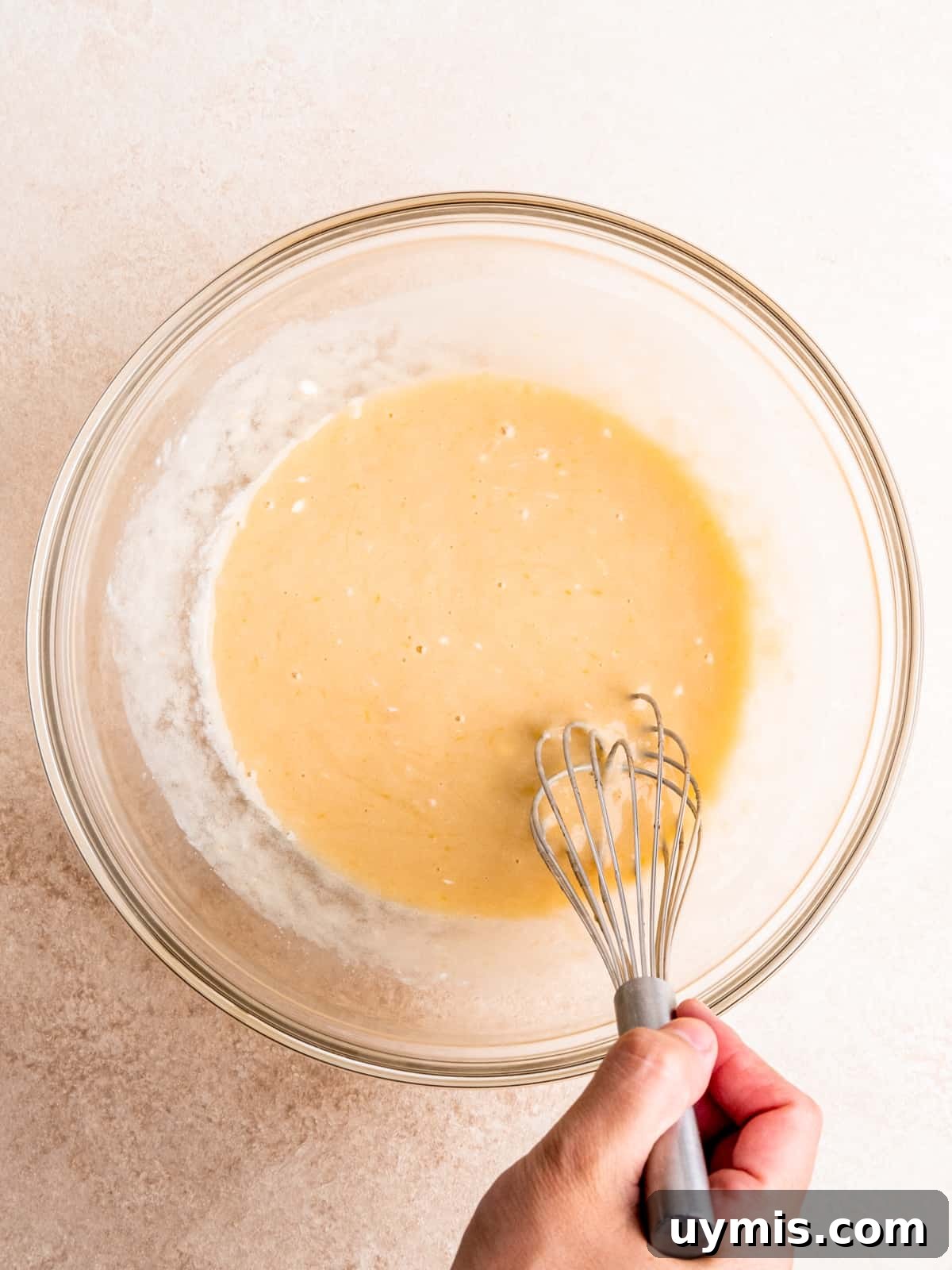 Whisking oil, sugars, egg, sour cream and milk in a bowl.
