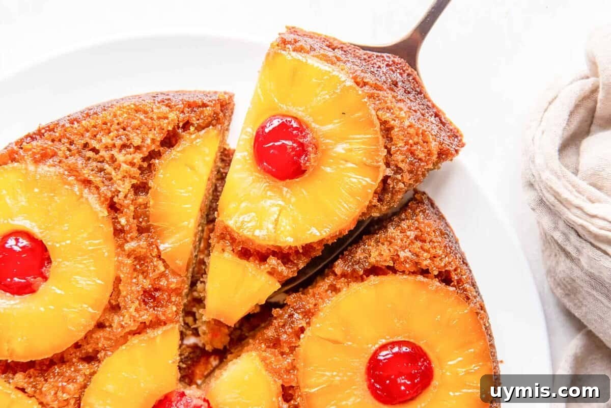 Labor Day Dessert Recipes for Summer Cookouts 5 close up overhead view of a slice of pineapple upside down cake being removed with a cake server.