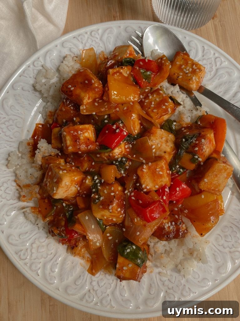 Gluten-Free Vegan Sweet Chili Tofu Recipe 4 Vegan and Gluten Free Sweet Chili Tofu Recipe over white rice with mixed veggies served on a white glass plate.