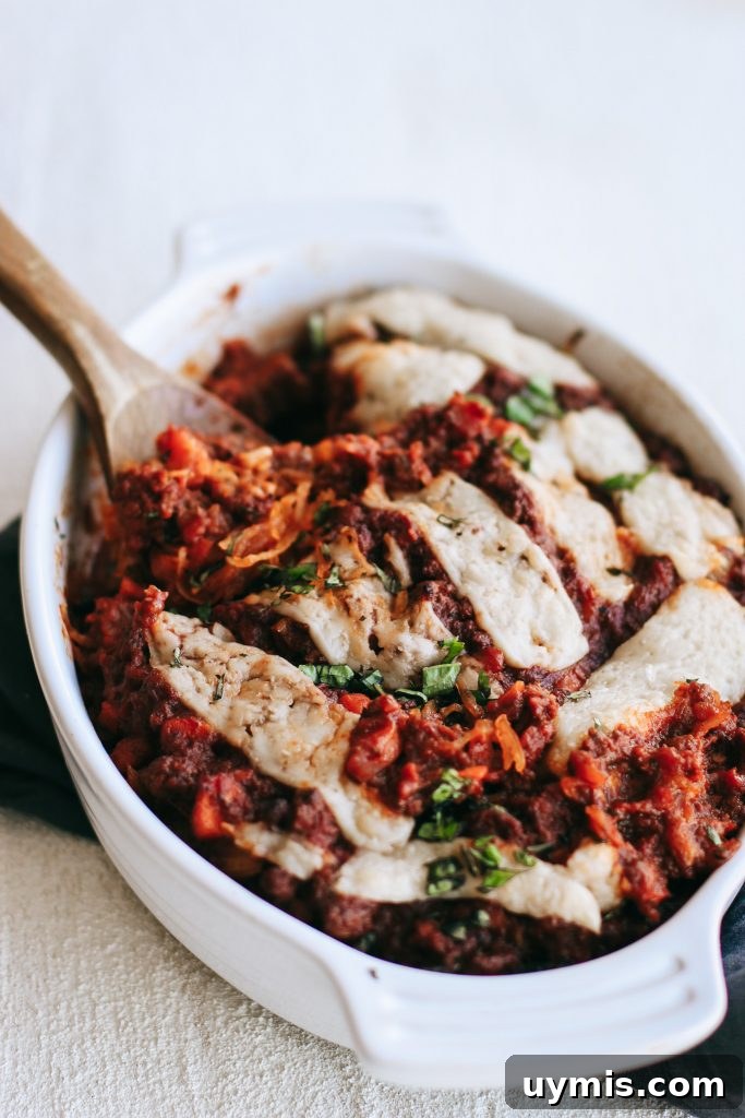 Spaghetti squash bake in a white dish with a wooden spoon