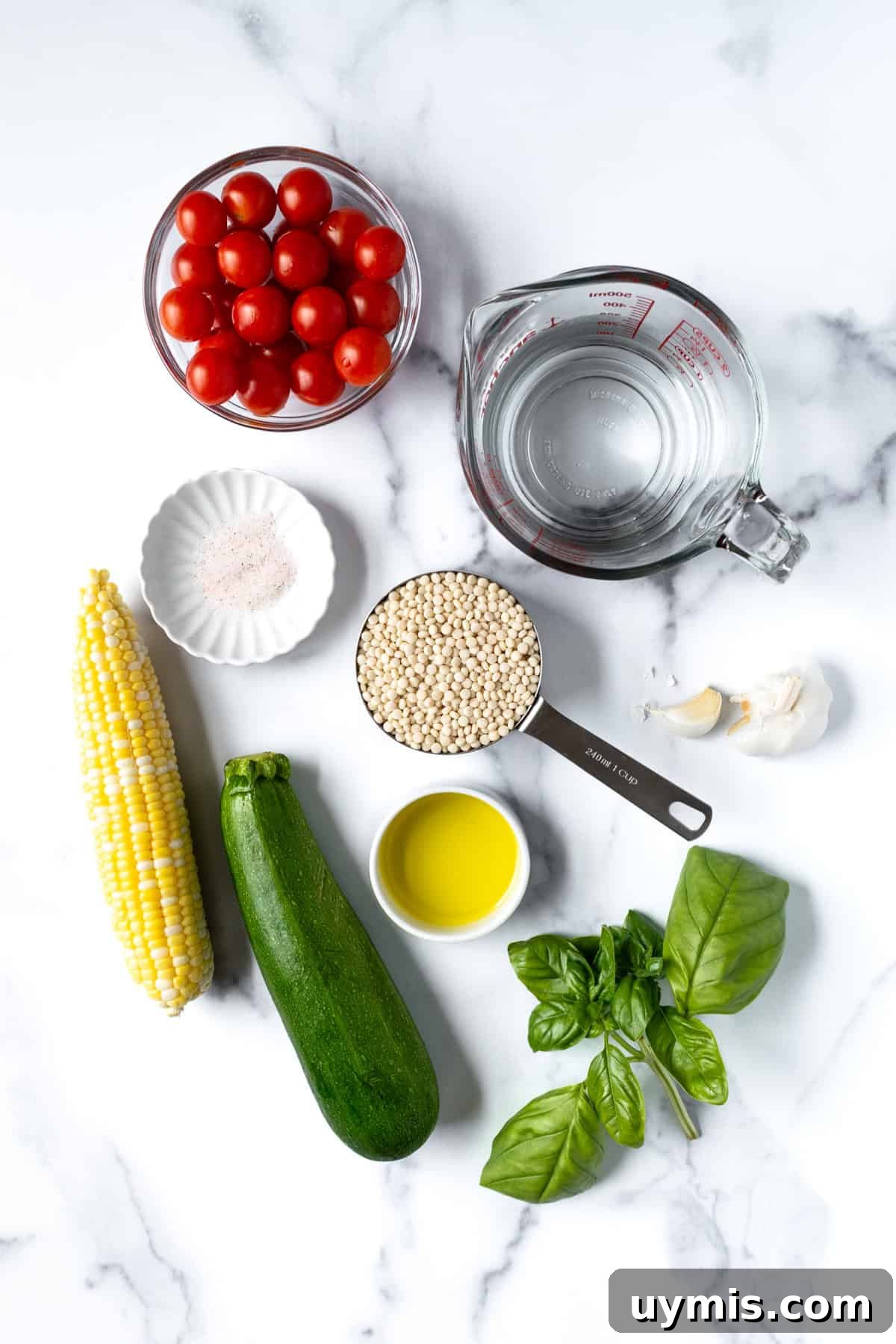 Zesty Summer Couscous Salad with Fresh Herbs 3 Summer Pearl Couscous Ingredients on a marble countertop.