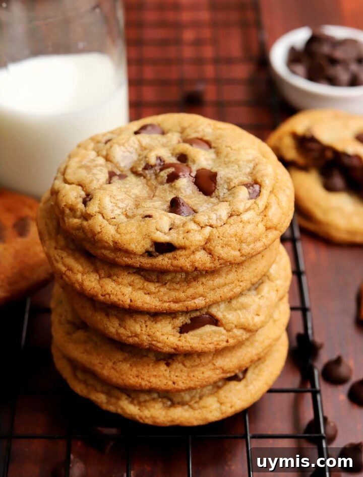 No-Chill Chocolate Chip Cookie Recipe 3 stack of best brown butter chocolate chip cookies on cooling rack with glass of milk