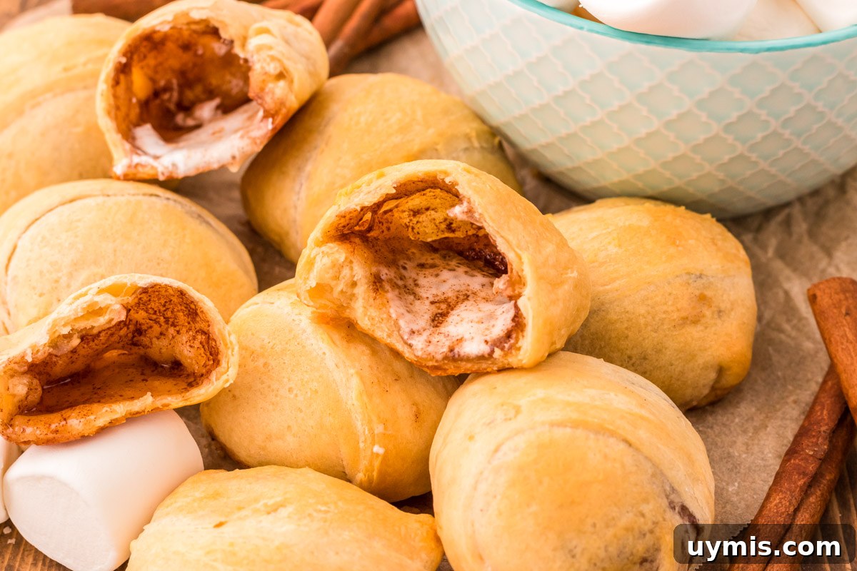Easter Resurrection Rolls with Marshmallow Center 7 Empty Tomb Rolls piled on top of each other, some have been broken open to reveal the inside.