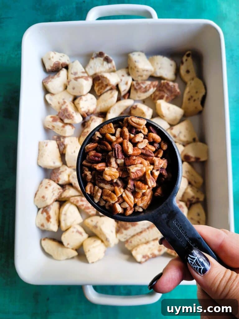 Sprinkling chopped pecans over the custard-covered cinnamon rolls before baking.
