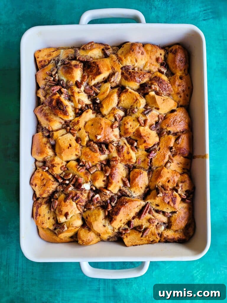 Golden-baked cinnamon roll breakfast casserole cooling on the counter before icing drizzle.
