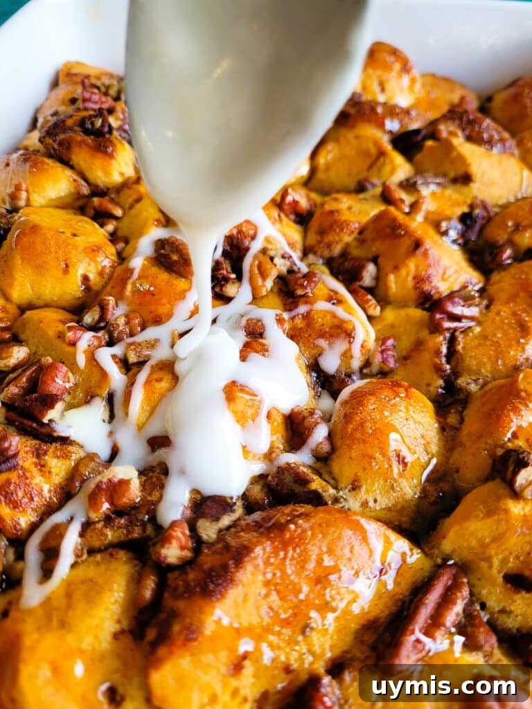 drizzling icing over baked cinnamon roll casserole
