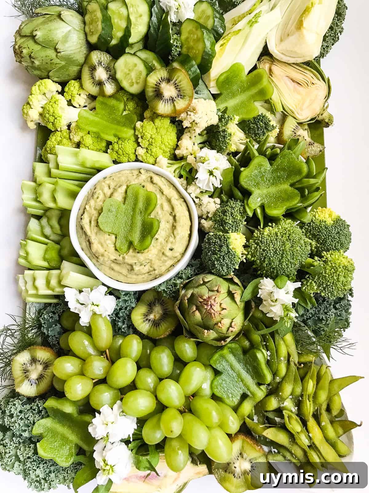 St. Patrick's Day Green Snack Ideas for Parties 2 A large tray of green vegetables and a green dip with a shamrock cut out of green bell pepper.