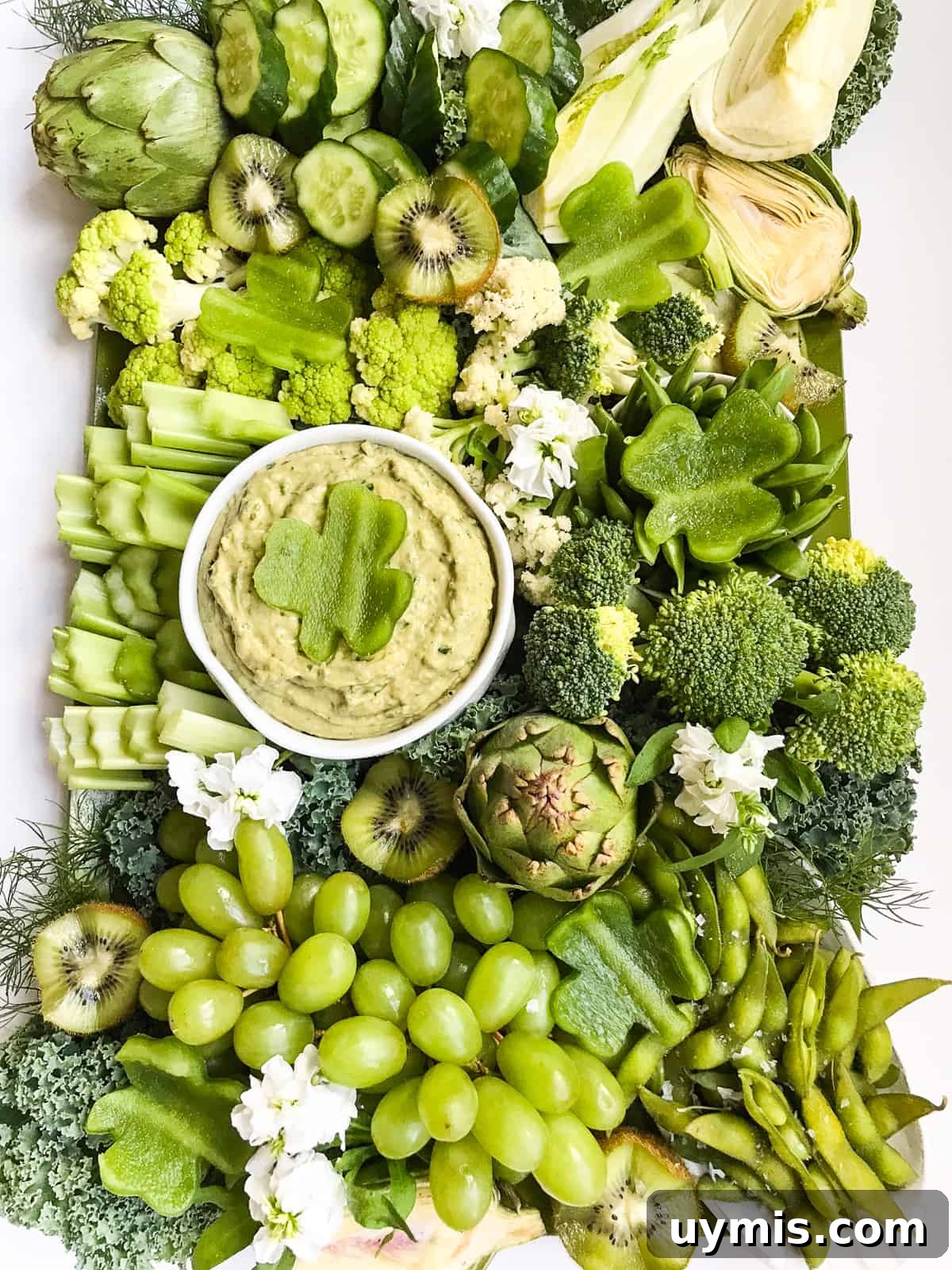 St. Patrick's Day Green Snack Ideas for Parties 4 A large green food vegetable and fruit tray with a green dip in a white bowl for St Patrick's Day.