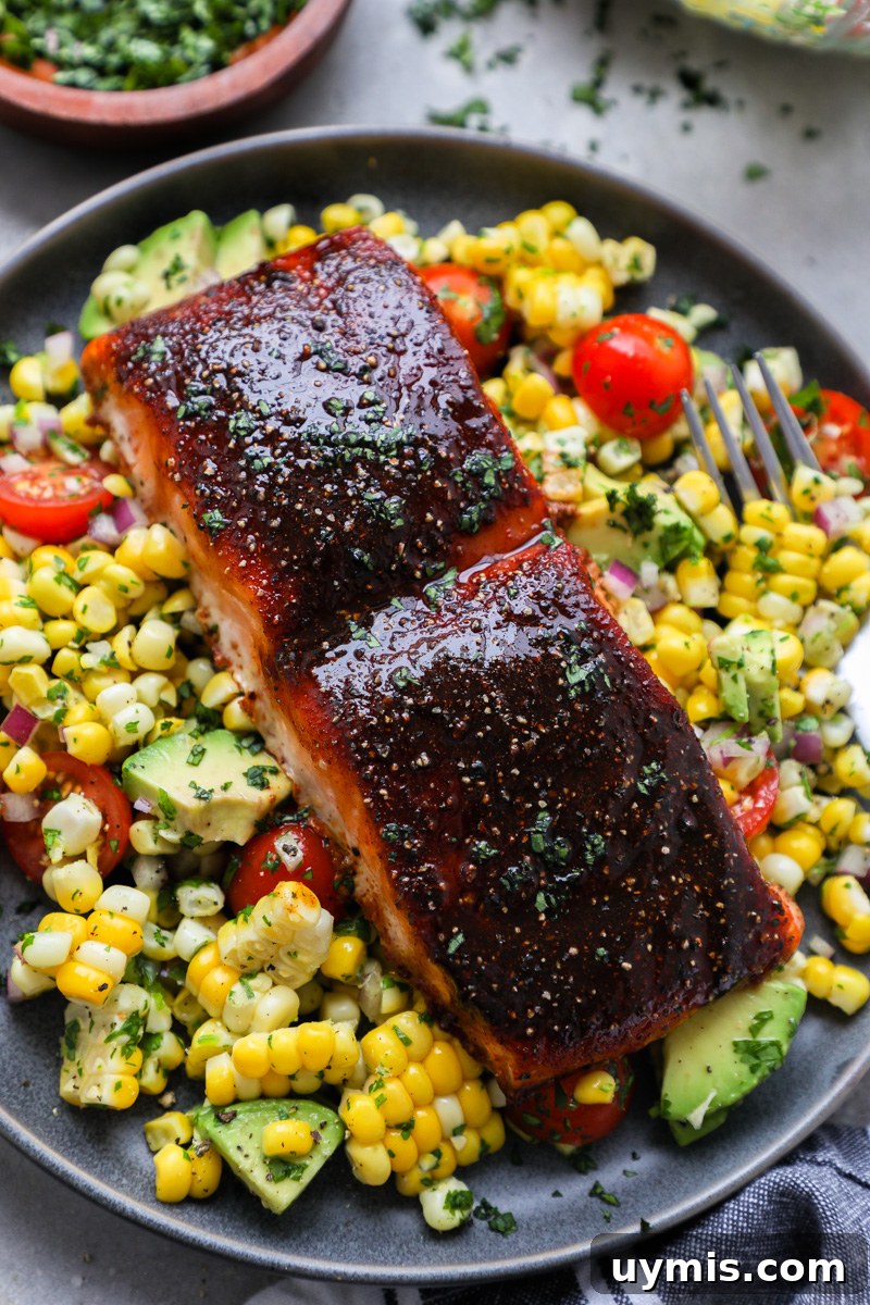 Oven-Baked Brown Sugar-Spiced Salmon 7 A plate filled with summer corn salad topped with a freshly baked sugar spiced salmon fillet