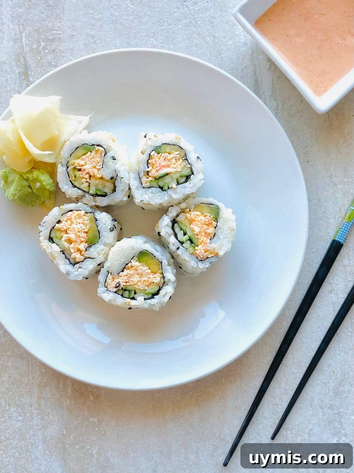 How to Make Spicy Kani Roll — Japanese Crab Sushi 2 kani sushi roll on a plate with chopsticks